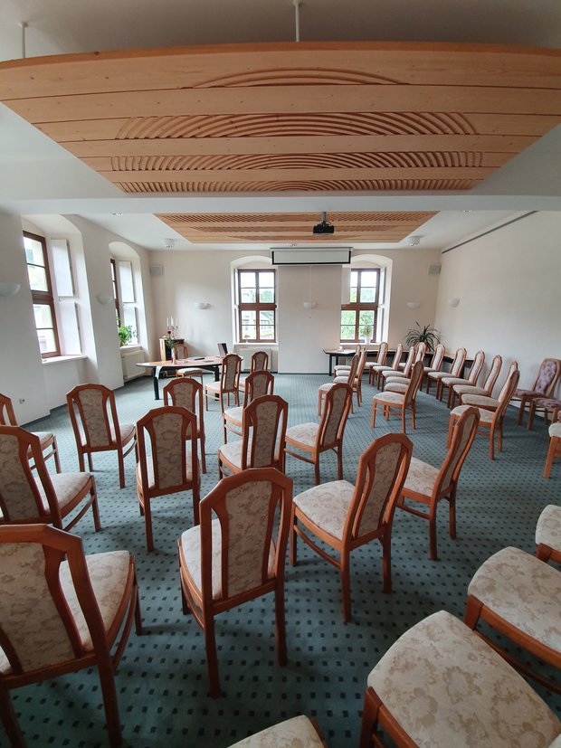 Blick in ein Zimmer mit Stühlen ohne Personen.